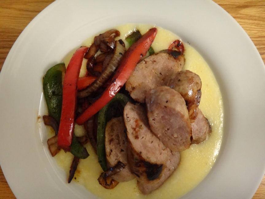 Italian sausage with peppers and onions over cheese grits